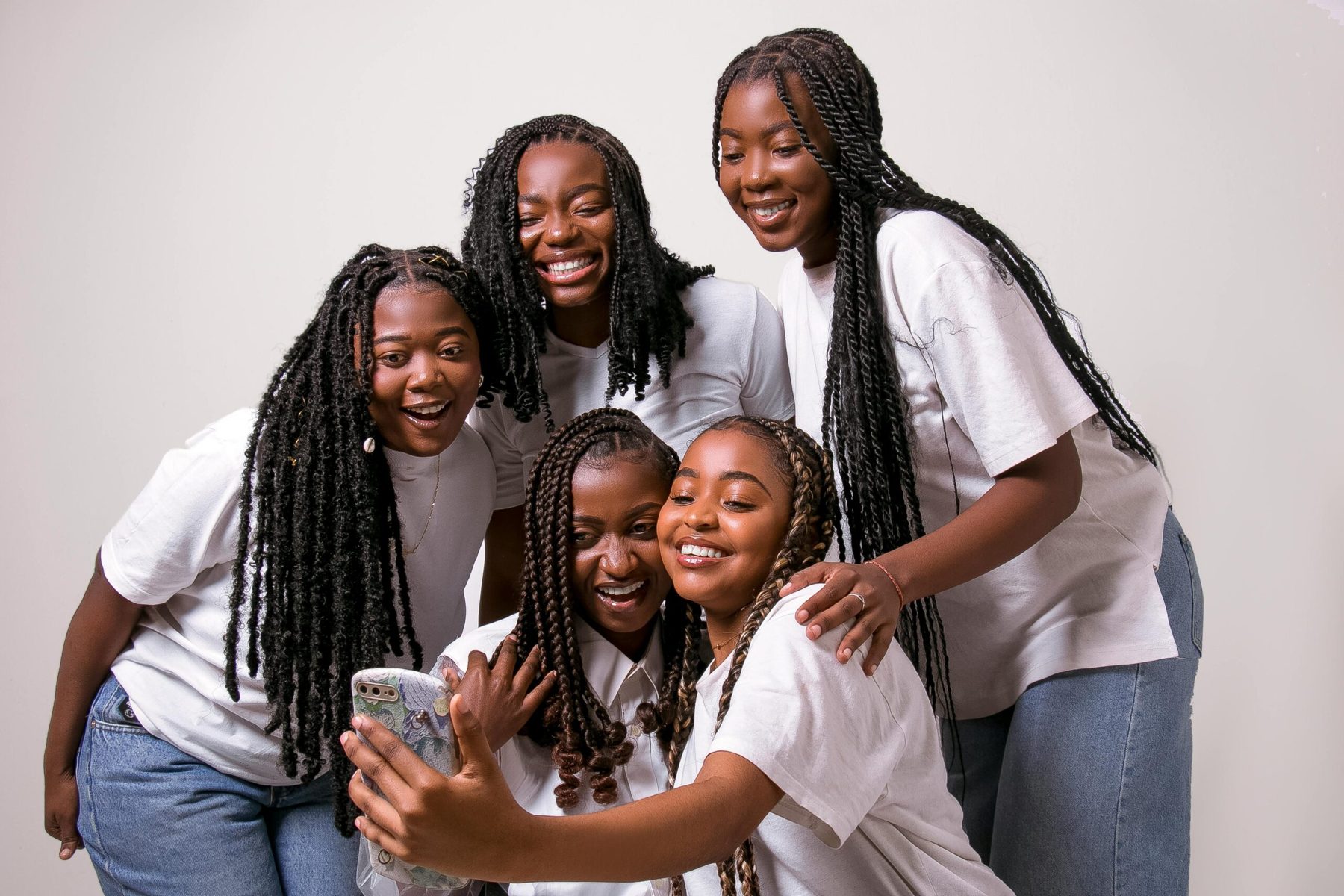 Smiling girls in white T-shirts taking a group selfie